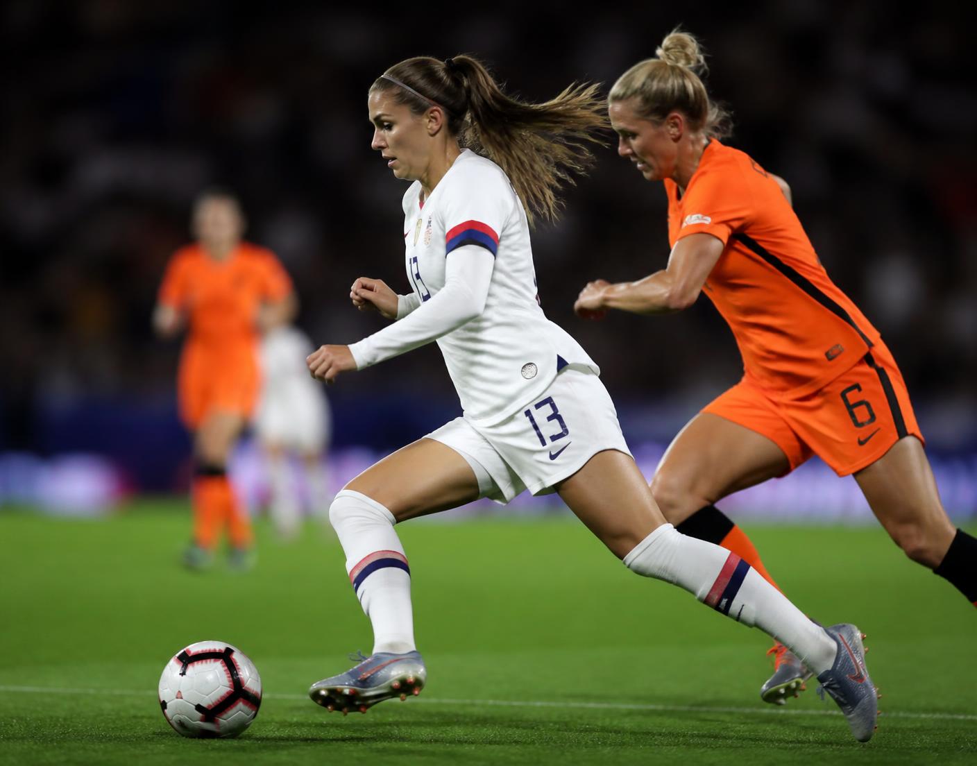 Atletas de futebol feminino profissional disputando a bola em campo